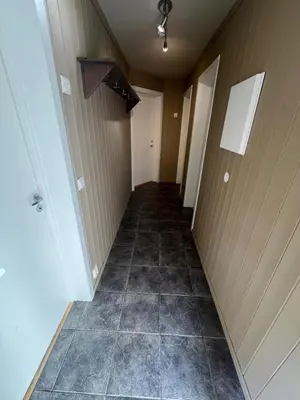 an empty hallway with a tile floor in a room at Ski in ski out apartment with sauna in Hemsedal