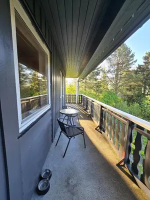 a porch with a table and a bench on a balcony at Brendefur Panorama in Hornindal
