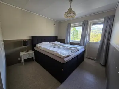 a bedroom with a large bed in a room with a window at Brendefur Panorama in Hornindal