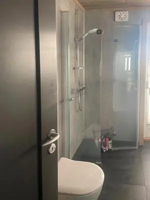a bathroom with a toilet and a glass shower at Modern Cabin With Views Of Langsua National Park in Etnedal