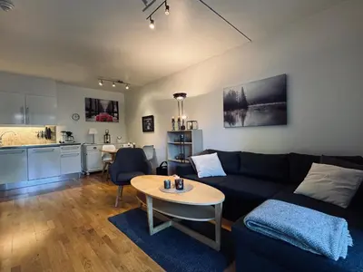 a living room with a couch and a table and a kitchen at Central Apartment in Geilo in Geilo