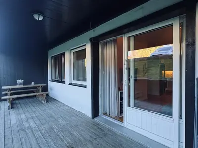 a porch with a bench on the side of a house at Central Apartment in Geilo in Geilo