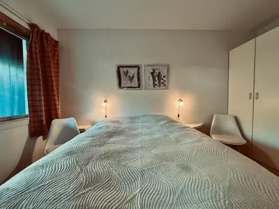 a bedroom with a large bed and two chairs at Central Apartment in Geilo in Geilo