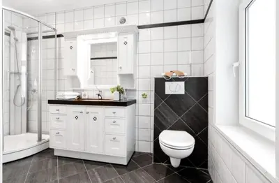 a white bathroom with a toilet and a sink at Central, lovely apartment with a unique view in Bergen