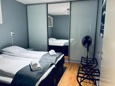 a room with two beds and a mirror at Central Apt - Steps to Fish Market and Bryggen in Bergen