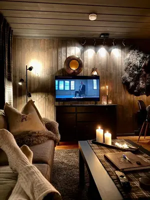 a living room with a tv and a couch and a table at Charming cabin with lovely views at Geilo in Geilo