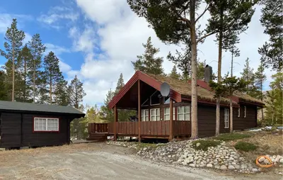 a log cabin with a porch and a house at Amazing Home In Lesjaverk With Wi-Fi in Bjorli