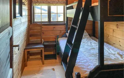 a room with a bunk bed and a chair in it at Pet Friendly Home In Bjorli With Sauna in Bjorli