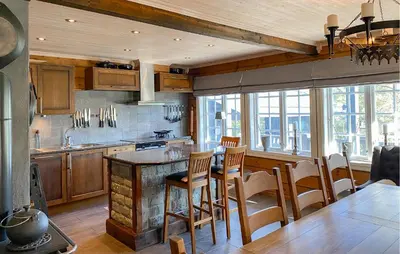 a kitchen with wooden cabinets and a table and chairs at Pet Friendly Home In Bjorli With Sauna in Bjorli