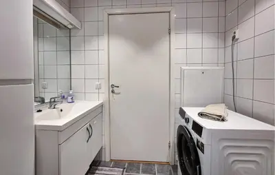 a bathroom with a washing machine and a sink at Awesome Apartment In Ulvik With House Sea View in Ulvik