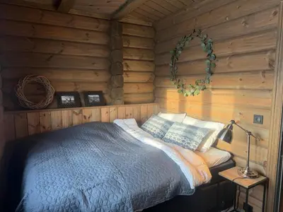 a bedroom with a bed in a log cabin at Fjellhytte Med 4 Soverom, Sauna, Peis Og Terrasse in Beitostøl