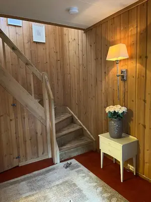 a wooden staircase in a room with a table and a lamp at Home with a view in Lom