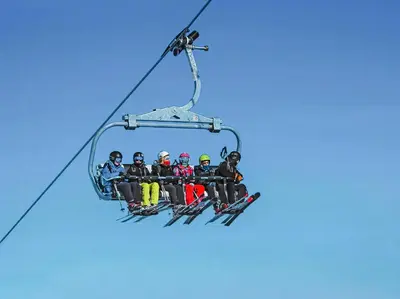 a group of people sitting on a ski lift at Cosy Cabin By Golsfjellet Ski Resort in Gol