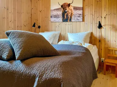 a bedroom with a bed with a picture of a bull at Cosy Cabin By Golsfjellet Ski Resort in Gol