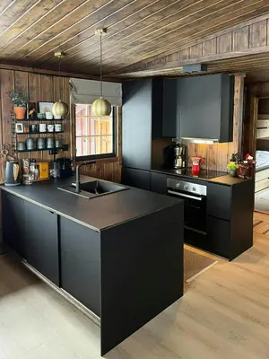 a kitchen with black cabinets and a black counter top at Modern Mountain Cabin With Views Over Slokovannet in Nore