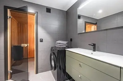 a bathroom with a washing machine and a sink at Ski out ski in Luxus Hemsedal in Hemsedal
