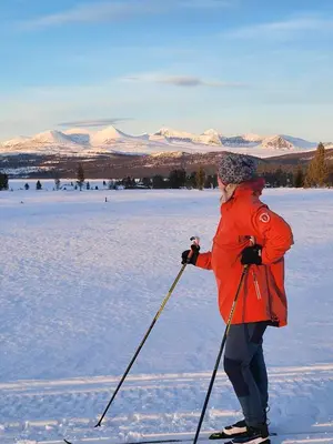 a woman is standing on skis in the snow at Kvamsfjellet - Rondane in Nord-Fron