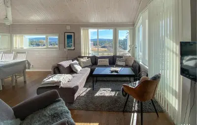 a living room with a couch and a table at 3 Bedroom Cozy Home In Sjusjøen in Sjusjøen