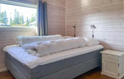 a bed with pillows on it in a room with a window at 3 Bedroom Cozy Home In Sjusjøen in Sjusjøen