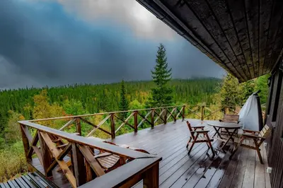a wooden deck with chairs and a table on it at Trysilfjellet Nord 267 in Trysil