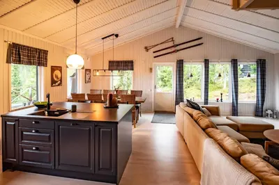 a kitchen and living room with a couch and a table at Trysilfjellet Nord 267 in Trysil