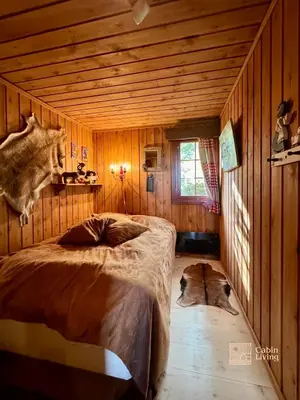 a bedroom with a bed and two dogs laying on the floor at Ski in-out cabin Trysil sauna, fireplace and views in Trysil