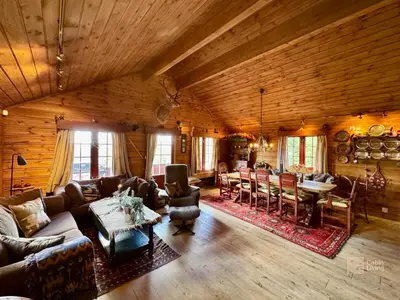 a living room with a couch and a dining room at Ski in-out cabin Trysil sauna, fireplace and views in Trysil