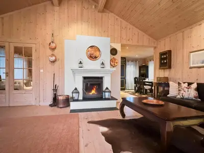 a living room with a fireplace and a table at Mountain cabin in Aurdal Fireplace Sauna 1000 meters above sea level in Aurdal