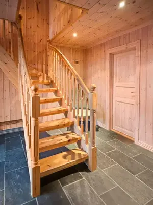 a wooden staircase in a log cabin with a door at Mountain cabin in Aurdal Fireplace Sauna 1000 meters above sea level in Aurdal