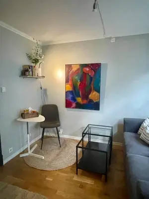 a living room with a couch and a table and a painting at Central studio apartment in Bergen
