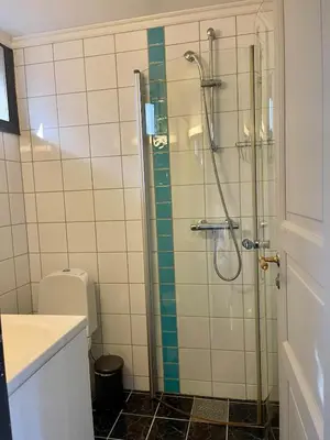 a bathroom with a glass shower with a toilet at Central studio apartment in Bergen