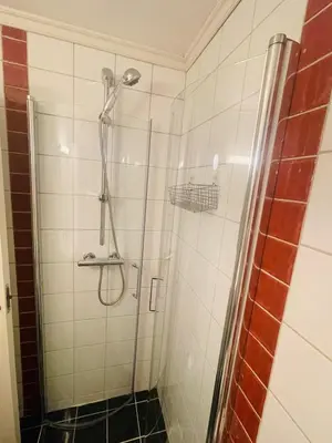 a bathroom with a shower with a glass door at Central studio apartment in Bergen