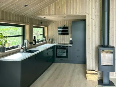 a kitchen with gray cabinets and a sink and a stove at Renovated Cabin With Views Over Breimsvatnet in Klakegg