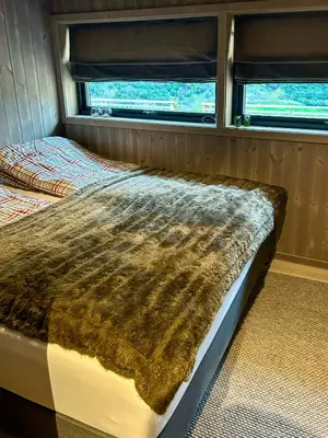 a bed in the back of a van with a fur blanket at Renovated Cabin With Views Over Breimsvatnet in Klakegg