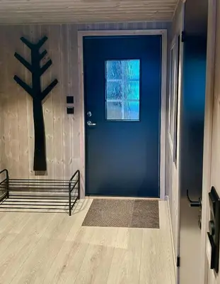 a blue door in a room with a tree on the wall at Renovated Cabin With Views Over Breimsvatnet in Klakegg