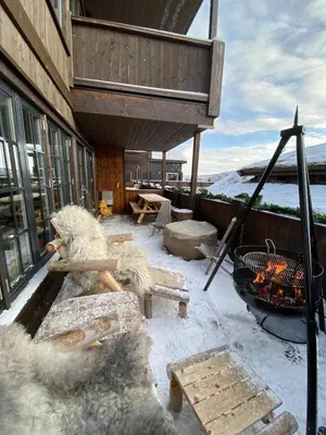 a snow covered patio with a fireplace and a grill at Hovden Alpin Lodge Appartement in Bykle