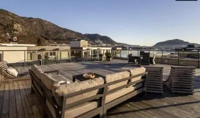 a deck with a view of the water and mountains at Flott leilighet mellom sjø og fjell in Bergen