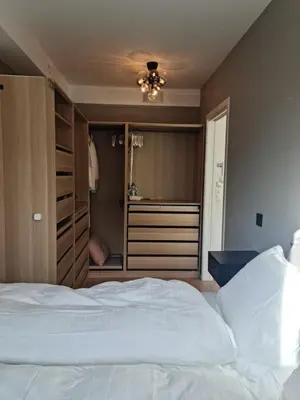 a bedroom with a large white bed and a closet at Flott leilighet mellom sjø og fjell in Bergen