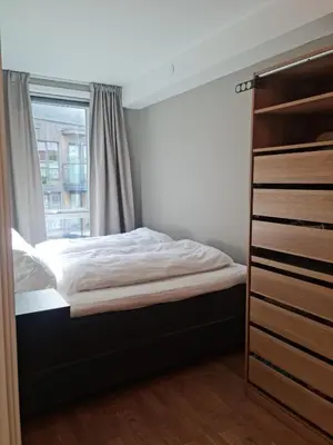 a bedroom with a bed and a window at Flott leilighet mellom sjø og fjell in Bergen