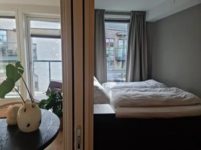 a small bedroom with a bed and a window at Flott leilighet mellom sjø og fjell in Bergen