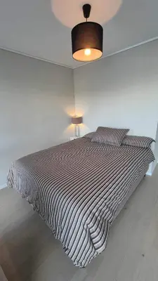 a bed in a bedroom with a striped bedspread at Apartment in Ålesund in Ålesund