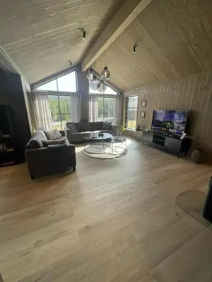 a large living room with a couch and a tv at New cabin in Slåseterlia at Skeikampen in Svingvoll