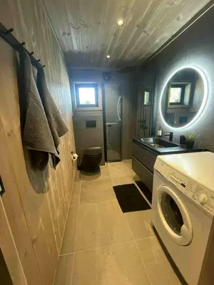 a bathroom with a washing machine and a sink at New cabin in Slåseterlia at Skeikampen in Svingvoll