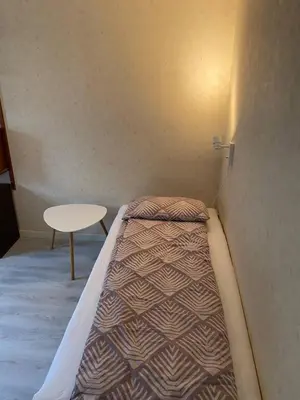 a small bedroom with a bed and a table at Mountain Retreat in Brattvg - Unwind in Nature in Brattvåg
