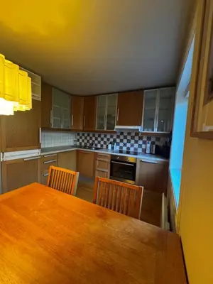 a large kitchen with a wooden table and chairs at Gimleveien 36G in Bergen