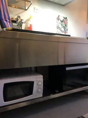 a microwave oven sitting on top of a kitchen counter at Compact living with all you need, close to the centre! in Røros