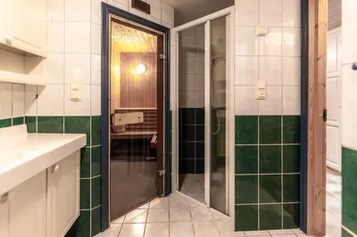 a bathroom with a shower with green and white tiles at Bakkebyvegen 7B in Trysil
