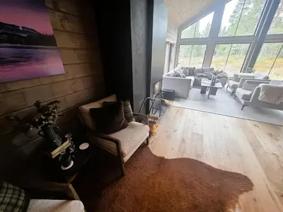a living room with couches and a large window at Unique hytta with jacuzzi, sauna, 7 bedrooms in Trysil