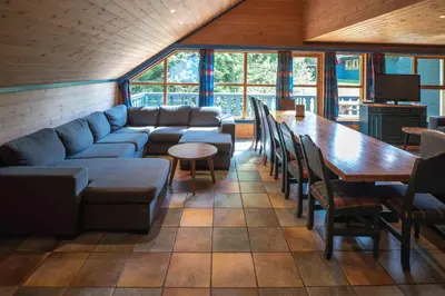 a living room with a couch and a table and chairs at Bakkebyvegen 13A in Trysil