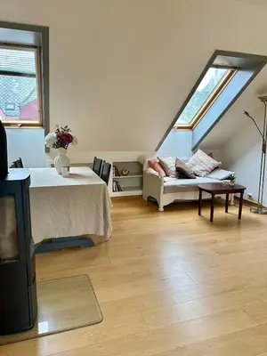 a room with a bed and a couch and a window at Bright loft apartment in a Jugend-style building close to Brosund in Ålesund